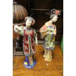 A PAIR OF ORIENTAL CERAMIC LADY FIGURES WITH TUBE LINED DETAIL AND STAMPS TO BASE