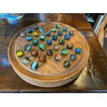 A CIRCULAR HARDWOOD SOLITAIRE BOARD WITH 32 MARBLES, circa 1900