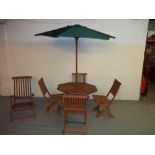 A WOODEN FOLD AWAY GARDEN TABLE SET WITH FOUR CHAIRS, A LOUNGER AND A PARASOL