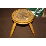 A CARVED WOODEN STOOL