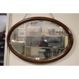 AN OVAL FRAMED MIRROR 64 X 49 CM