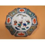 A SHAPED ORIENTAL DISH WITH FIGURATIVE DETAIL AND CHARACTER MARKINGS TO BASE