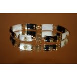 AN ORIENTAL 9CT GOLD MOTHER OF PEARL & BLACK ONYX STYLE BRACELET STAMPED 375