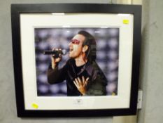 A FRAMED AND GLAZED U2 INTEREST SIGNED PHOTOGRAPH OF BONO