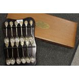 A SET OF TWELVE HALLMARKED SILVER RSPB INTEREST SPOONS WITH BIRD FINIALS ON HANGING WALL RACK