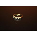 A HALLMARKED 9 CARAT GOLD SEVEN STONE DRESS RING - SIZE O - WEIGHT 1.4 GRAMS APPROX