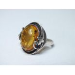 A LARGE SILVER MOUNTED AMBER RING