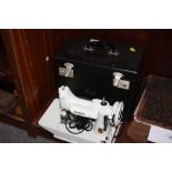 A SMALL CASED ELECTRIC 221K SINGER SEWING MACHINE