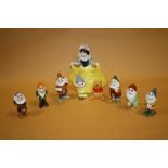 A DISNEY CERAMIC SNOW WHITE AND THE SEVEN DWARVES FIGURE SET TOGETHER WITH A DISNEY WINNIE THE