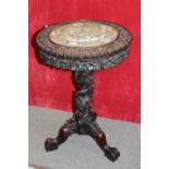 AN ORIENTAL CARVED PEDESTAL OCCASIONAL TABLE, the shaped top having an inset famille rose circular