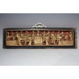 AN ORIENTAL CARVED AND GILT WOOD RECTANGULAR PANEL, modelled as figures carved in relief around a