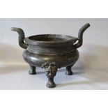 A LARGE ORIENTAL BRONZED TWIN HANDLED CENSOR, the outswept handles leading from a patterned