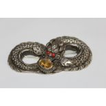 A VINTAGE WHITE METAL CHINESE DRAGON TYPE BROOCH, set with a citrine style stone by the mouth and