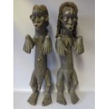 A PAIR OF WEST AFRICAN CARVED TRIBAL FIGURES, depicting a man and woman in traditional dress, H 62
