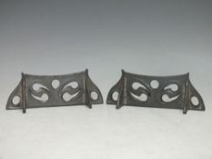 A PAIR OF ARTS & CRAFTS LIBERTY & Co. PEWTER KNIFE RESTS, with Art Nouveau pierced scrolling