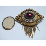 A VICTORIAN TYPE MOURNING BROOCH, with central cabochon stone and white enamel detail, removable