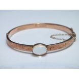 A HALLMARKED 9 CT ROSE GOLD BANGLE, set with a moonstone, approx weight 7.6g