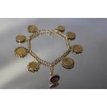 A 9CT GOLD ROLLER CHAIN SET WITH AN ORNATE AMETHYST SEAL AND EIGHT ASSORTED GOLD COINS, comprising f