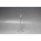 AN ANTIQUE GLASS SLENDER CORDIAL TYPE GOBLET, having an oversized circular foot supporting a slender