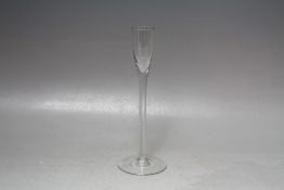 AN ANTIQUE GLASS SLENDER CORDIAL TYPE GOBLET, having an oversized circular foot supporting a slender