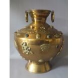 A DECORATIVE INDIAN BRASS VASE ON FOOTED BASE, of circular form, with raised and embossed mask,