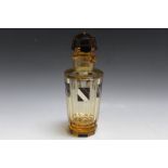 AN ART DECO GLASS DECANTER WITH ENAMEL DECORATION, pale amber coloured faceted body with black and