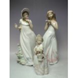 TWO LARGE NAO FIGURES OF YOUNG GIRLS IN COSTUME HOLDING FLOWERS, tallest H 33 cm, together with a