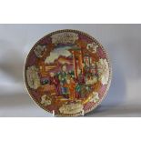 AN ORIENTAL FAMILLE ROSE SHALLOW PLATE, decorated with figures beside a pagoda, animal and floral