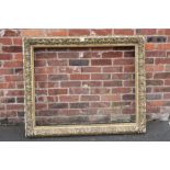 A 19TH CENTURY DECORATIVE GOLD FRAME, frame W 11 cm, rebate approx 88 x 114 cm