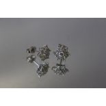 A PAIR OF SEVEN STONE DIAMOND EARRINGS, in a foral style, butterfly stamped 750, W 1 cm