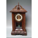 A LATE 19TH CENTURY CARVED OAK MANTEL CLOCK, the enamel dial with Roman numerals, visible anchor