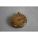 A YELLOW METAL FOB WATCH (marked 18ct), gilt engraved dial with black Roman Numeral markings.