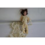 AN ANTIQUE FRENCH BISQUE HEADED DOLL, marked Paris to the back of the head and composition body A/