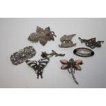A BAG OF MOSTLY SILVER BROOCHES TO INCLUDE A DRAGONFLY SHAPED EXAMPLE (8)