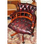 A REPRODUCTION OXBLOOD LEATHER OFFICE SWIVEL CHAIR