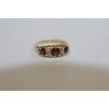 AN 18 CARAT GOLD THREE STONE GARNET DRESS RING - SIZE M - WEIGHT 2.4 GRAMS APPROX