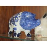 A LARGE FIGURE OF A SEATED PIG, TOGETHER WITH A BLUE AND WHITE PIGGY BANK OF LARGE PROPORTIONS (2)