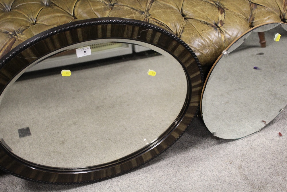 A CIRCULAR BEVEL EDGED WALL MIRROR TOGETHER WITH AN OVAL MIRROR