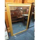 A LARGE GILT FRAMED BEVEL EDGED WALL MIRROR