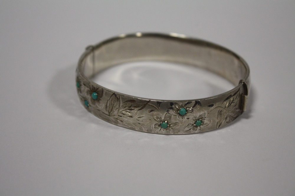 A HALLMARKED SILVER ENGRAVED BANGLE SET WITH TURQUOISE STONES