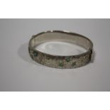 A HALLMARKED SILVER ENGRAVED BANGLE SET WITH TURQUOISE STONES