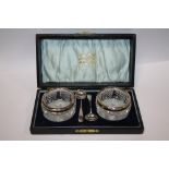 A PAIR OF BOXED SILVER RIMMED SALTS AND SPOONS