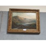 A GILT FRAMED OIL ON CANVAS DEPICTING A MOUNTAINOUS RIVER SCENE