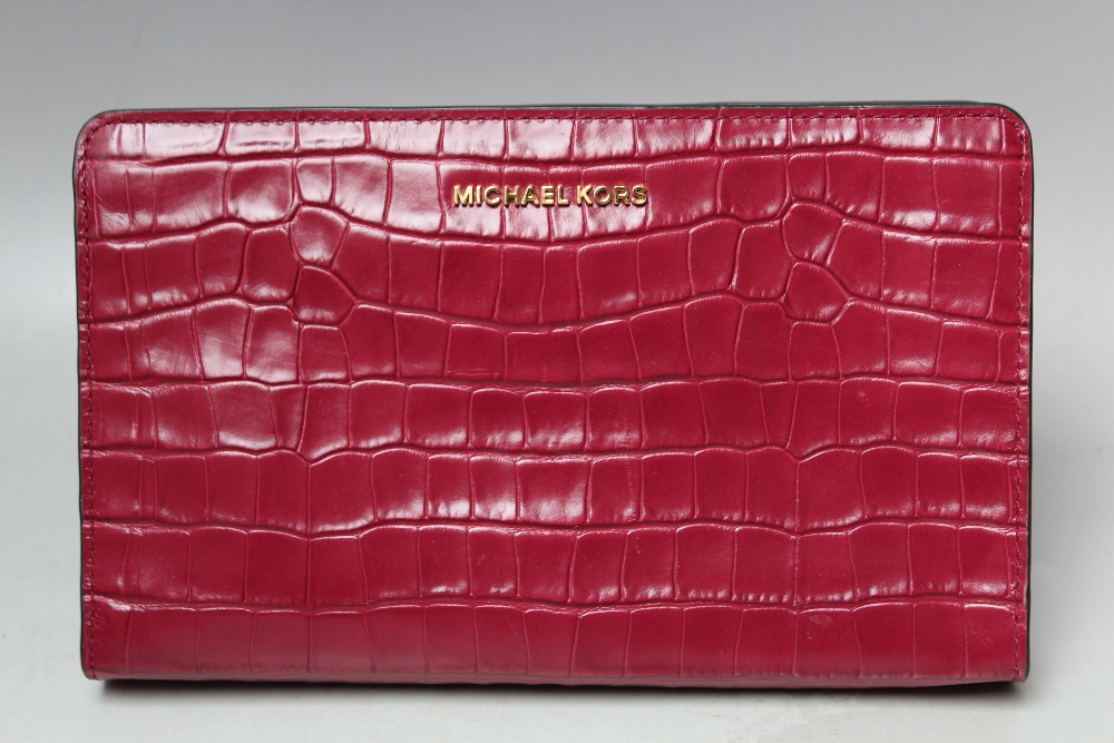 A MICHAEL KORS FUSHIA EMBOSSED LEATHER CROSS BODY CLUTCH BAG, single open pocket to reverse of bag