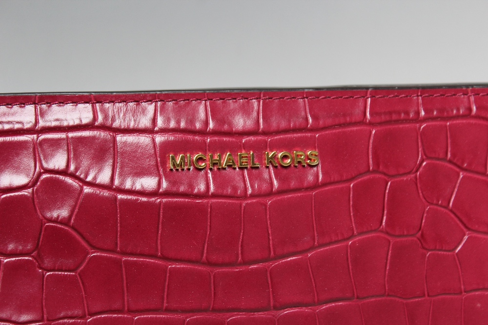 A MICHAEL KORS FUSHIA EMBOSSED LEATHER CROSS BODY CLUTCH BAG, single open pocket to reverse of bag - Image 2 of 4