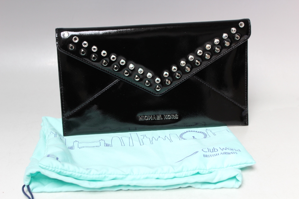 A MICHAEL KORS PATENT LEATHER CLUTCH BAG, envelope style with press stud fastening, gemset and