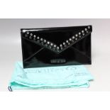 A MICHAEL KORS PATENT LEATHER CLUTCH BAG, envelope style with press stud fastening, gemset and