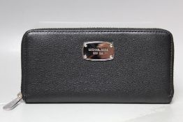 A MICHAEL KORS BLACK LEATHER LADIES WALLET, subtle textured effect finish, note compartments, zip