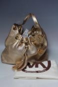 A MICHAEL KORS 'CAMDEN' LARGE LEATHER DRAWSTRING BAG IN GOLD, textured finish, with gold tone