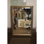 A GILT FRAMED MIRROR, 82 X 58 CM